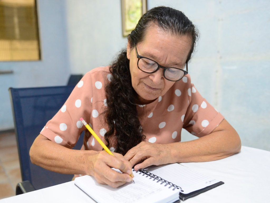 Con su lápiz y cuaderno Natividad realiza sus planas para repasar la escritura. Foto/ elsalvador.com