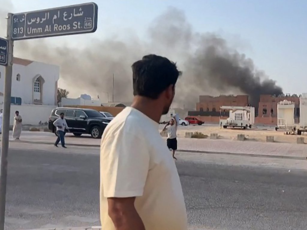Esta captura de pantalla, tomada de una grabación de AFPTV, muestra a un hombre observando una columna de humo tras las explosiones en Doha, la capital de Qatar, el 9 de septiembre de 2025. 
