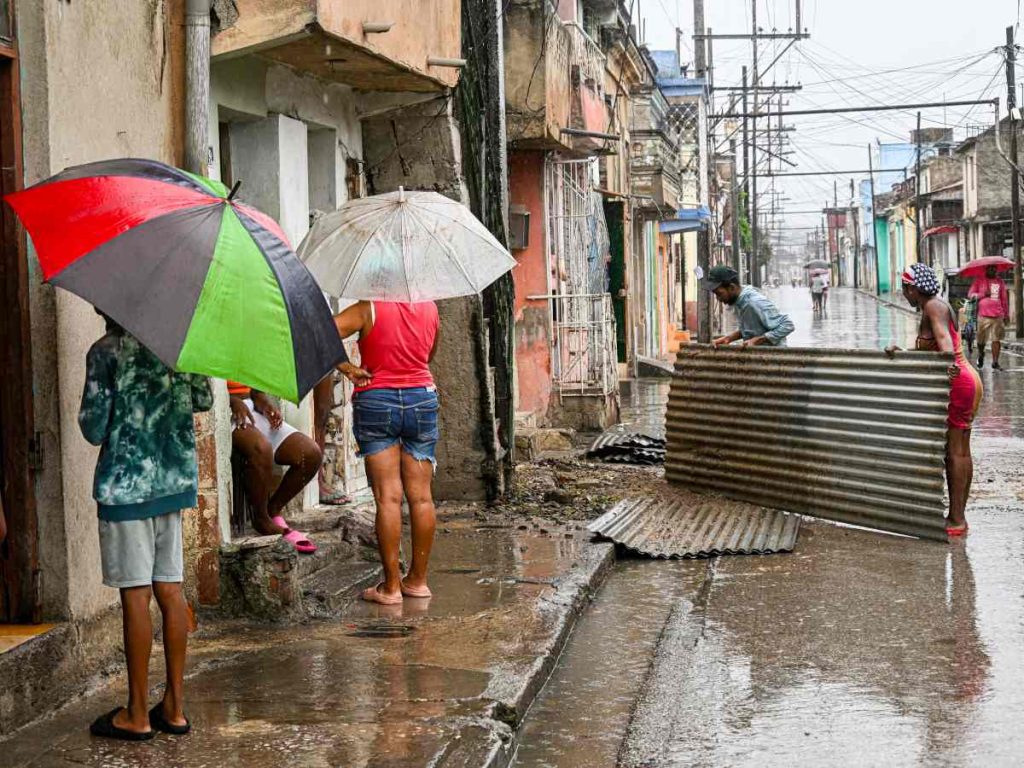 Los residentes sostienen pedazos del techo antes de que el huracán Melissa azote la ciudad de Santiago de Cuba, Cuba, el 28 de octubre de 2025.