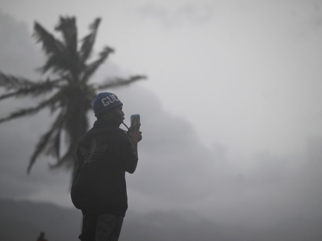 Un hombre usa su celular en el paseo marítimo de Kingston el 27 de octubre de 2025.