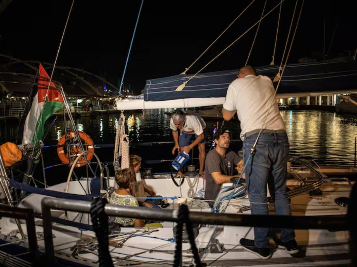 Personas conversan en un barco mientras esperan partir hacia Gaza para unirse a la Flotilla Global Sumud, en el puerto de Génova, el 30 de agosto de 2025. Foto: AFP