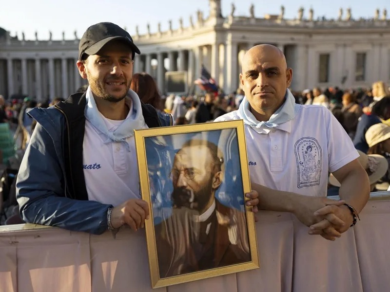 Fieles sostienen un retrato del abogado italiano Bartolo Longo en la Plaza de San Pedro, en el Vaticano.
