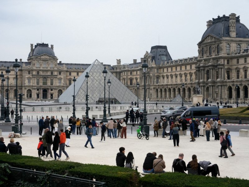 Turistas en las afueras del Museo del Louvre, en París, Francia, horas después del robo en el lugar. / AFP