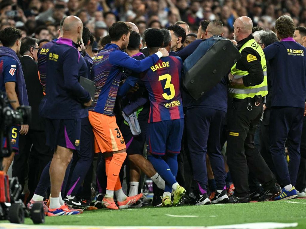 Los jugadores se pelean en la zona de banquillo durante el partido de fútbol de la liga española entre el Real Madrid CF y el FC Barcelona en el estadio Santiago Bernabéu