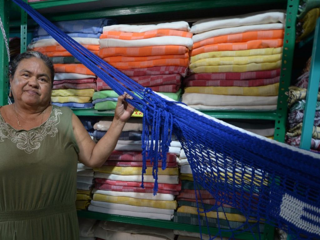 Roxana Barahona posa junto a una de las hamacas elaboradas en su taller familiar en San Sebastián. Fotografía/ elsalvador.com