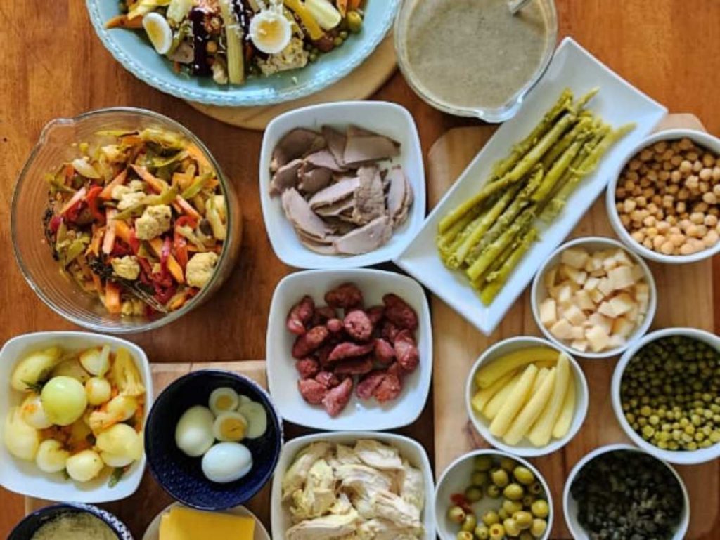 El fiambre combina embutidos, vegetales encurtidos, escabeches y un caldito especial, creando una mezcla única de sabores que refleja tradición y memoria.