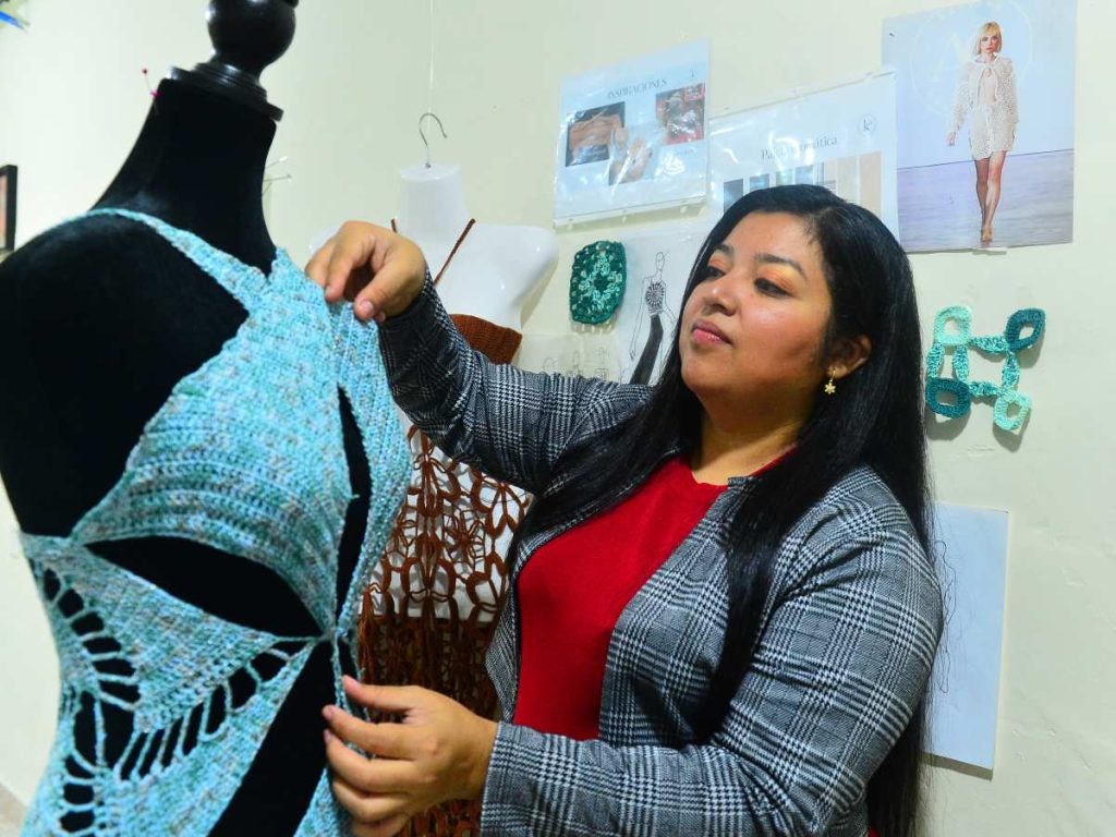 Kathya Galindo ajusta detalles de una creación tejida a mano, reflejo de su estilo artesanal y su compromiso por innovar desde las raíces del diseño salvadoreño.
