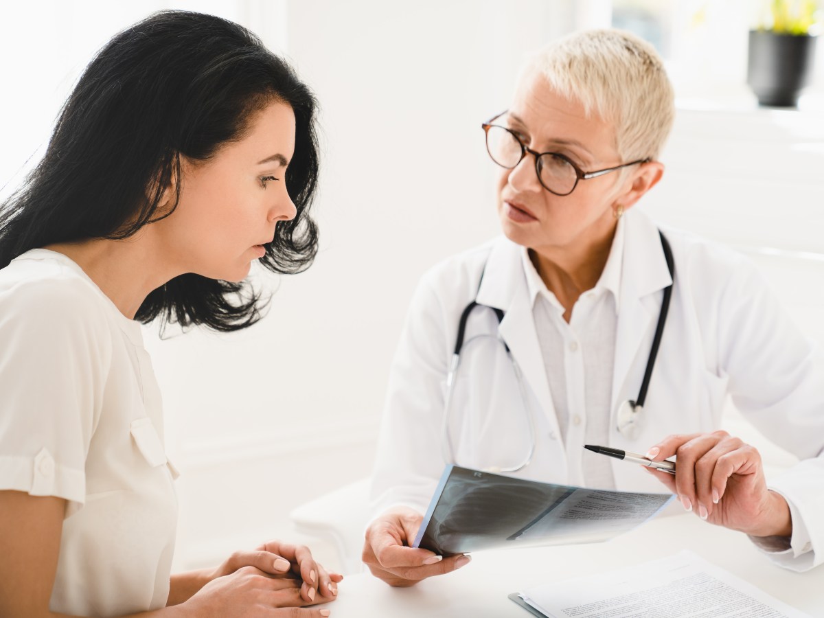 Una médica analiza una placa pulmonar con una paciente, en un contexto donde crecen los diagnósticos de cáncer de pulmón en personas no fumadoras y menores de 50 años.