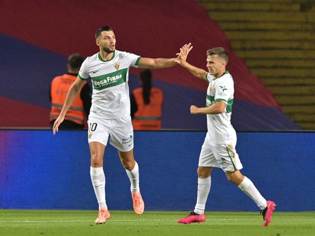 El delantero español del Elche, Rafa Mir (número 10), celebra el primer gol de su equipo durante el partido de liga español entre el FC Barcelona y el Elche CF.