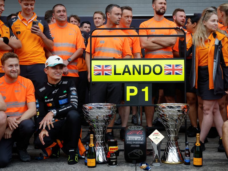 Lando Norris (abajo, de negro) festeja con su equipo McLaren tras imponerse en el Gran Premio de Sao Paulo. / Foto AFP