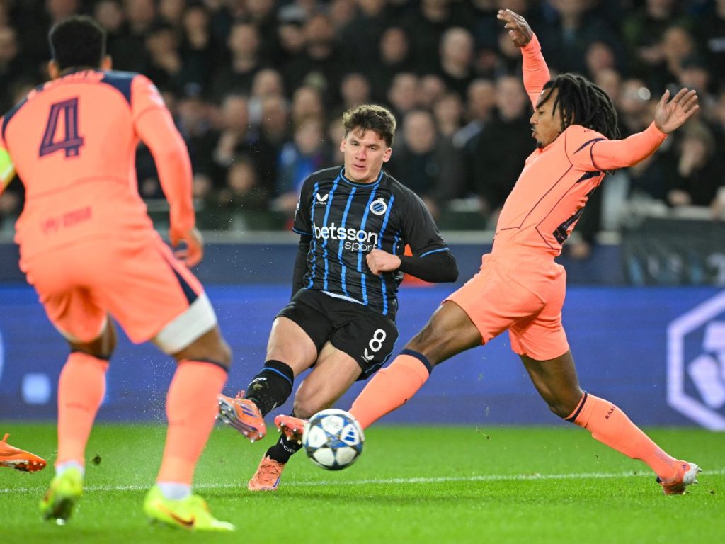 Jules Kounde (der.) y Ronald Araujo marcan a jugador del Brujas en la Champions League. Foto AFP