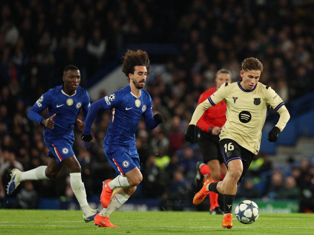 Marc Cucurella (centro) marca a Fermín en partido entre el Chelsea y Barcelona en la Champions League. Foto AFP 
