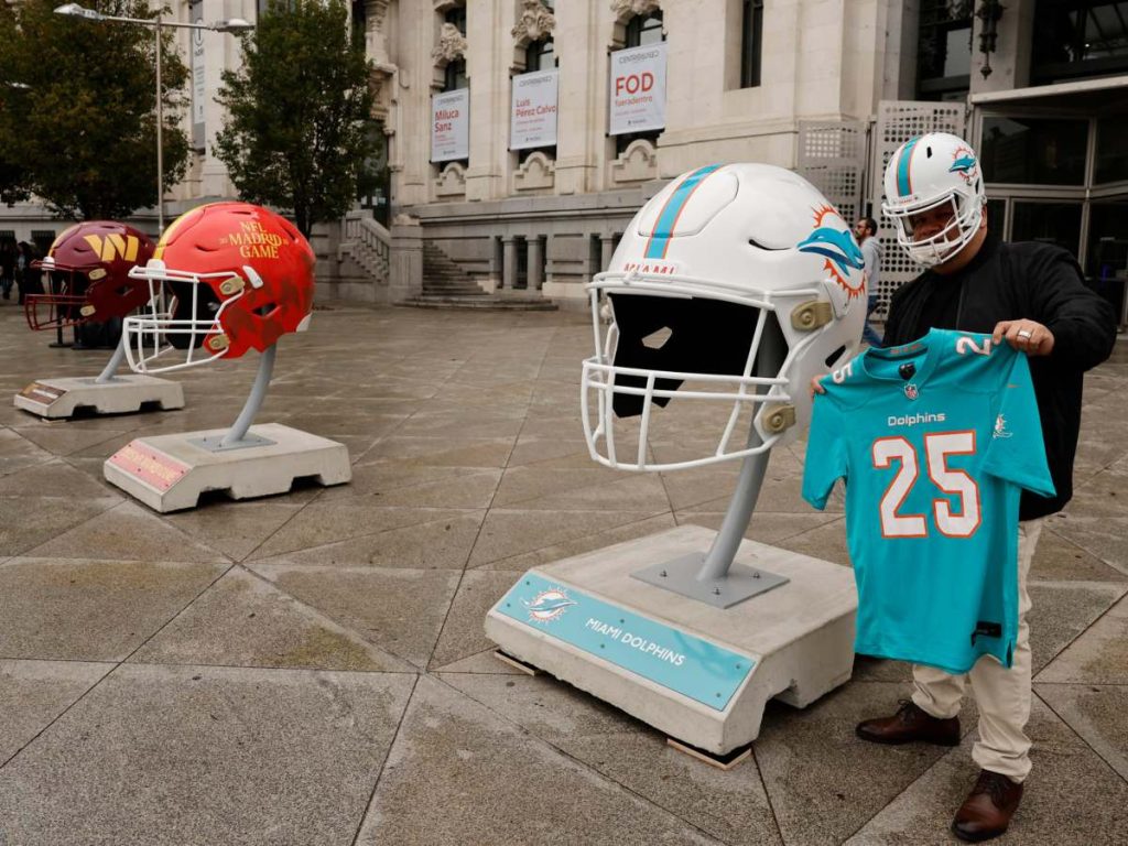 Varios cascos gigantes de fútbol americano NFL instalados frente al Palacio de Cibeles, actual sede del Ayuntamiento de Madrid, con motivo del primer partido oficial de la NFL de fútbol americano que enfrentará en el estadio Santiago Bernabéu a los Washington Commanders contra los Miami Dolphins, el próximo domingo. EFE