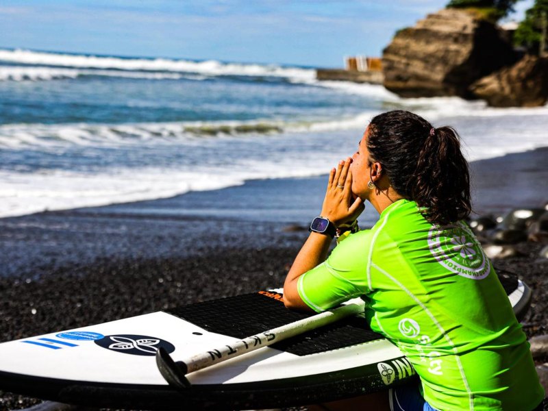 La surfista salvadoreña Josselyn Alabí se concentra hacia su participación en el Mundial de SUP Surf, en El Sunzal. / Foto X de Secretaría de Prensa