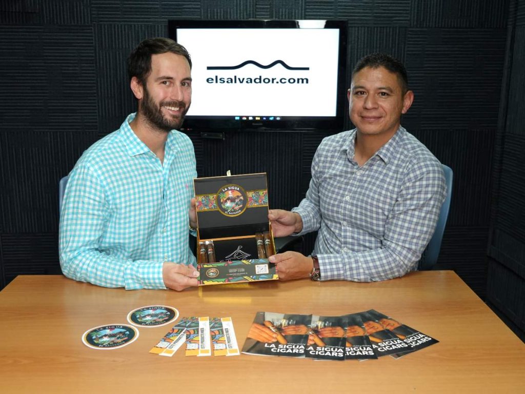 Los fundadores de La Sigua junto a un agricultor local en el cultivo de tabaco en tierras salvadoreñas. Al fondo, el volcán Izalco.