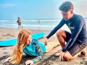 Jeffrey Chapetón, instructor y cofundador de Eterno Surf, brinda instrucciones a una alumna antes de ingresar al mar.