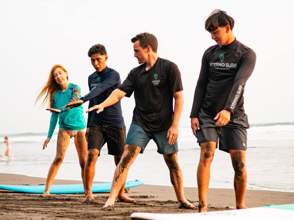 Participantes de Eterno Surf practican técnicas de equilibrio durante una sesión previa a entrar al agua.