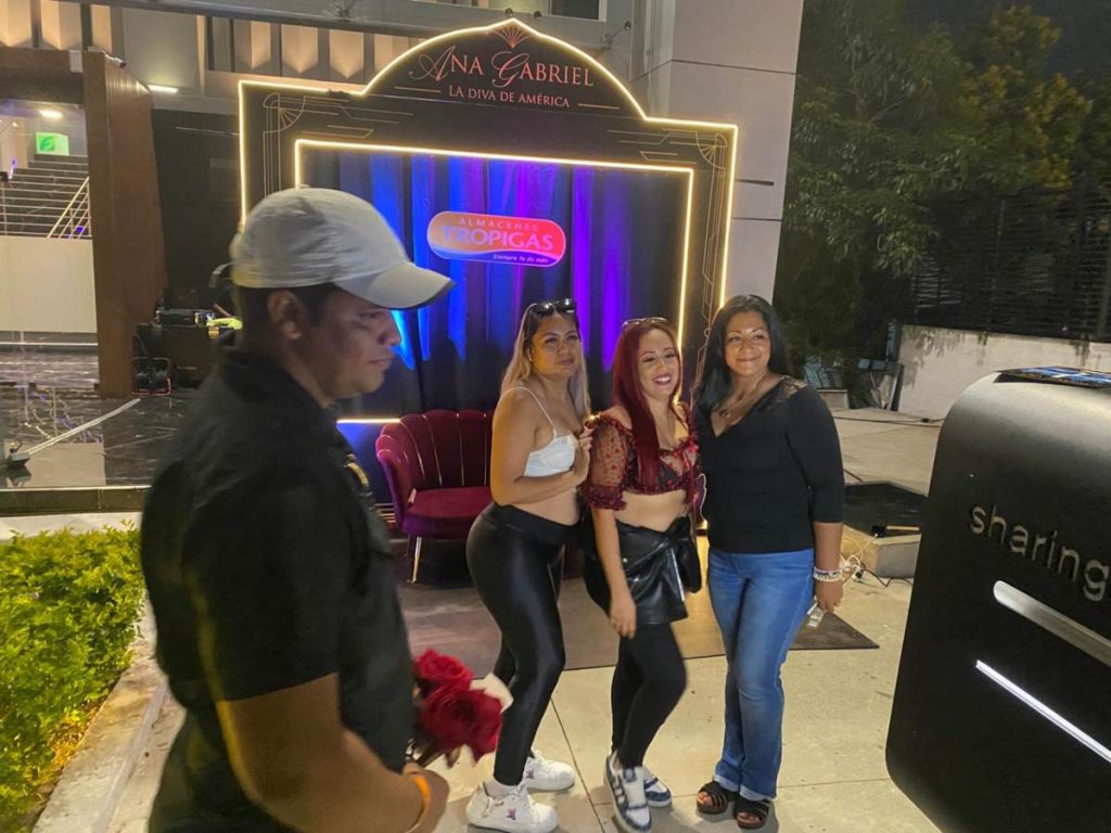 Fans disfrutan del área de fotos inspirada en Ana Gabriel antes del inicio del concierto en San Salvador.