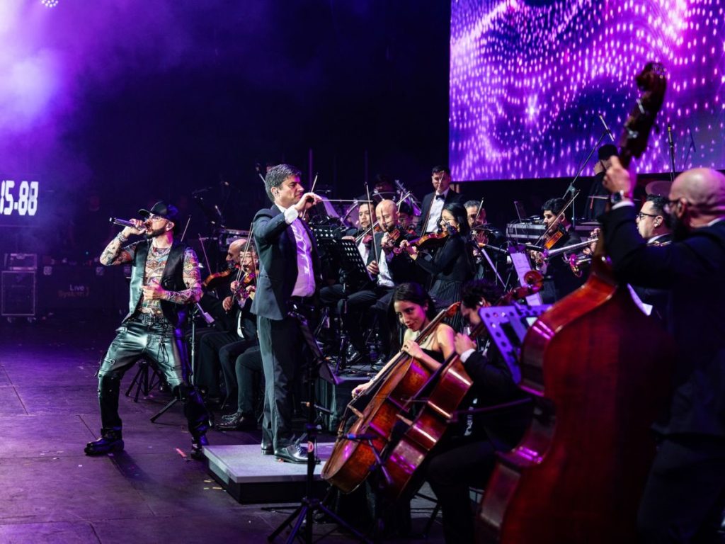 andel Sinfónico: una experiencia única donde los beats del reguetón se mezclan con la fuerza de más de 70 músicos en escena. Fotografía/ Facebook Yandel