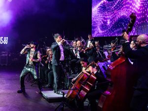 andel Sinfónico: una experiencia única donde los beats del reguetón se mezclan con la fuerza de más de 70 músicos en escena. Fotografía/ Facebook Yandel