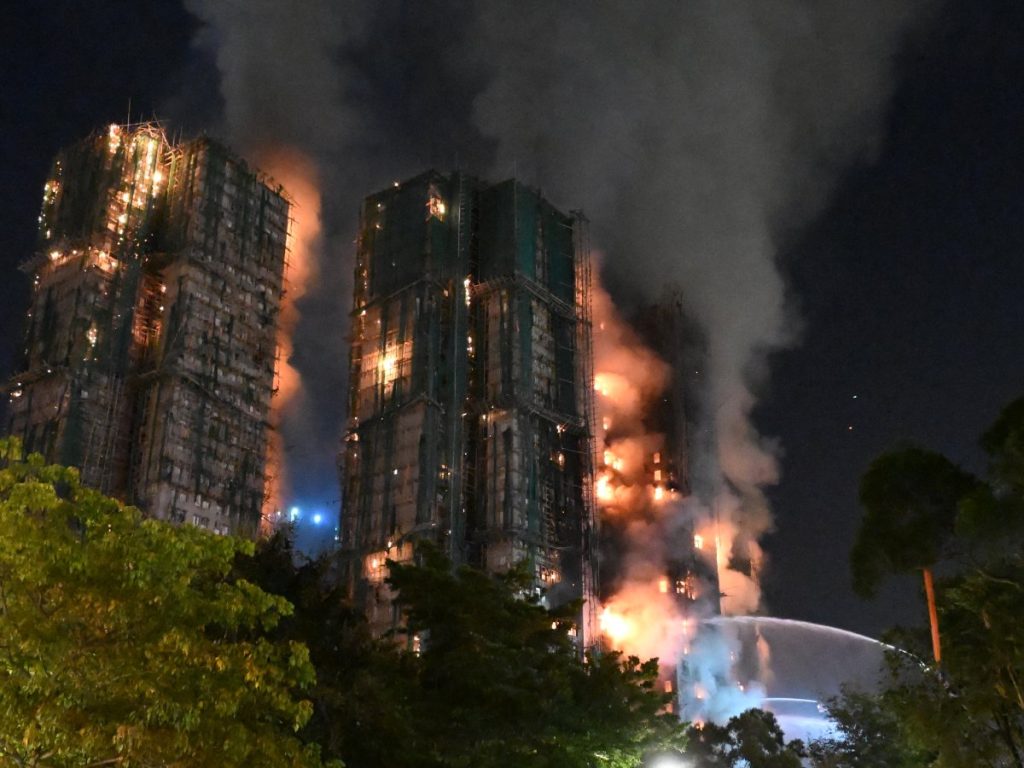 ista de los bloques residenciales de Wang Fuk Court envueltos en humo durante el incendio en Tai Po. Fotografía/AFP