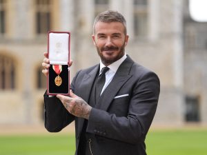El exfutbolista inglés David Beckham posa con su medalla tras ser nombrado caballero por sus servicios al deporte y a la beneficencia, durante una ceremonia de investidura en el castillo de Windsor el 4 de noviembre de 2025.