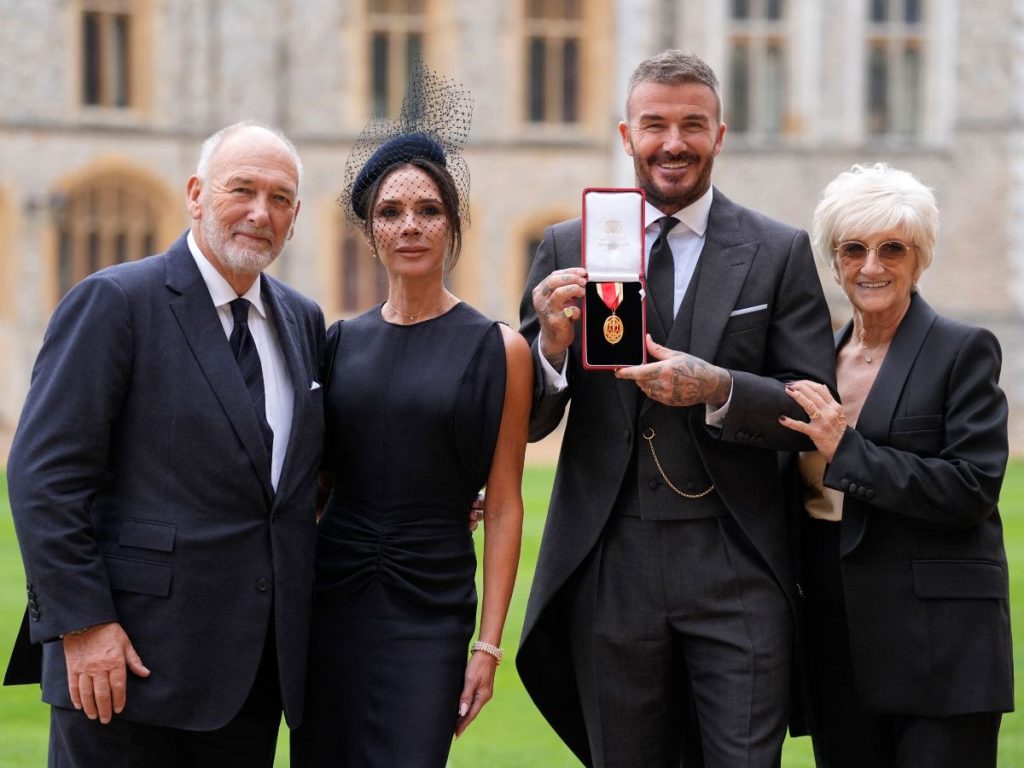 El exfutbolista inglés David Beckham (2° desde la derecha) posa con su medalla junto a su esposa, la cantante y diseñadora Victoria Beckham (izquierda), y sus padres, Ted (izquierda) y Sandra (derecha), tras ser nombrado caballero por sus servicios al deporte y a la beneficencia, durante una ceremonia de investidura en el castillo de Windsor el 4 de noviembre de 2025.