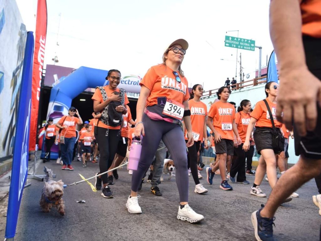 Una mascota acompaña a su dueña durante el recorrido de los 3 kilómetros, en un ambiente familiar y lleno de solidaridad.