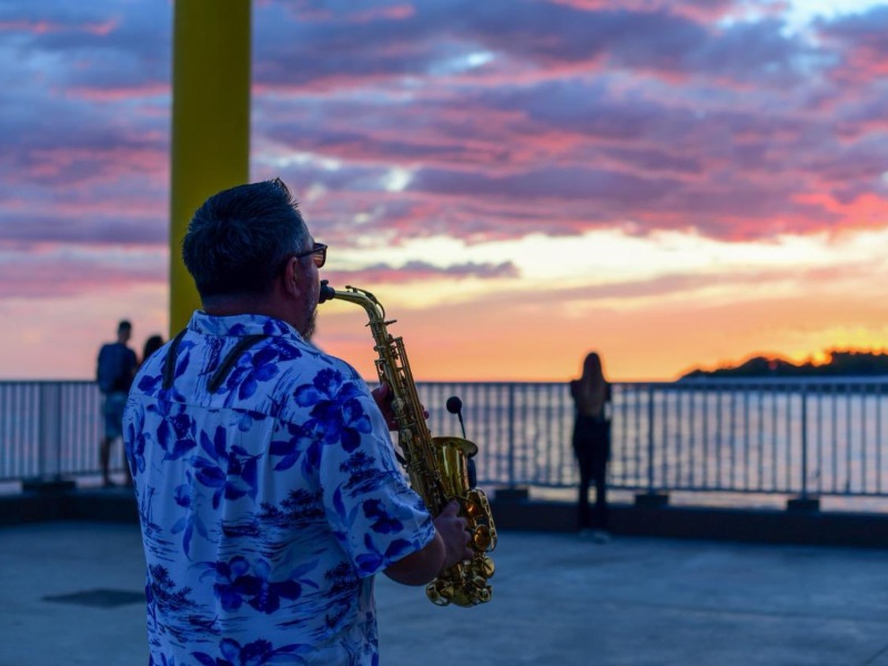 Visitantes disfrutan de música en vivo frente al mar en el Muelle Turístico de La Libertad, un espacio que combina cultura, gastronomía y recreación al aire libre.