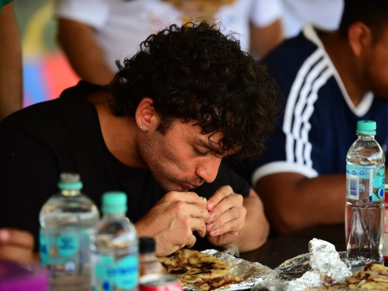 Michael, un joven estadounidense, logró comerse seis pupusas en el concurso, animado por los gritos y risas de sus amigos.