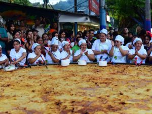 Entre aplausos, cámaras y música, los asistentes presenciaron la cocción de la pupusa más grande del festival.