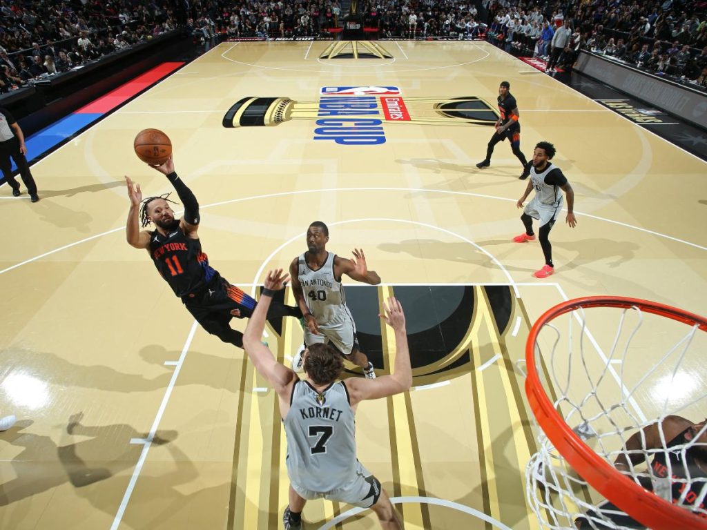 Jalen Brunson (izq.) atacando el aro con defensa de los Spurs. Foto AFP 