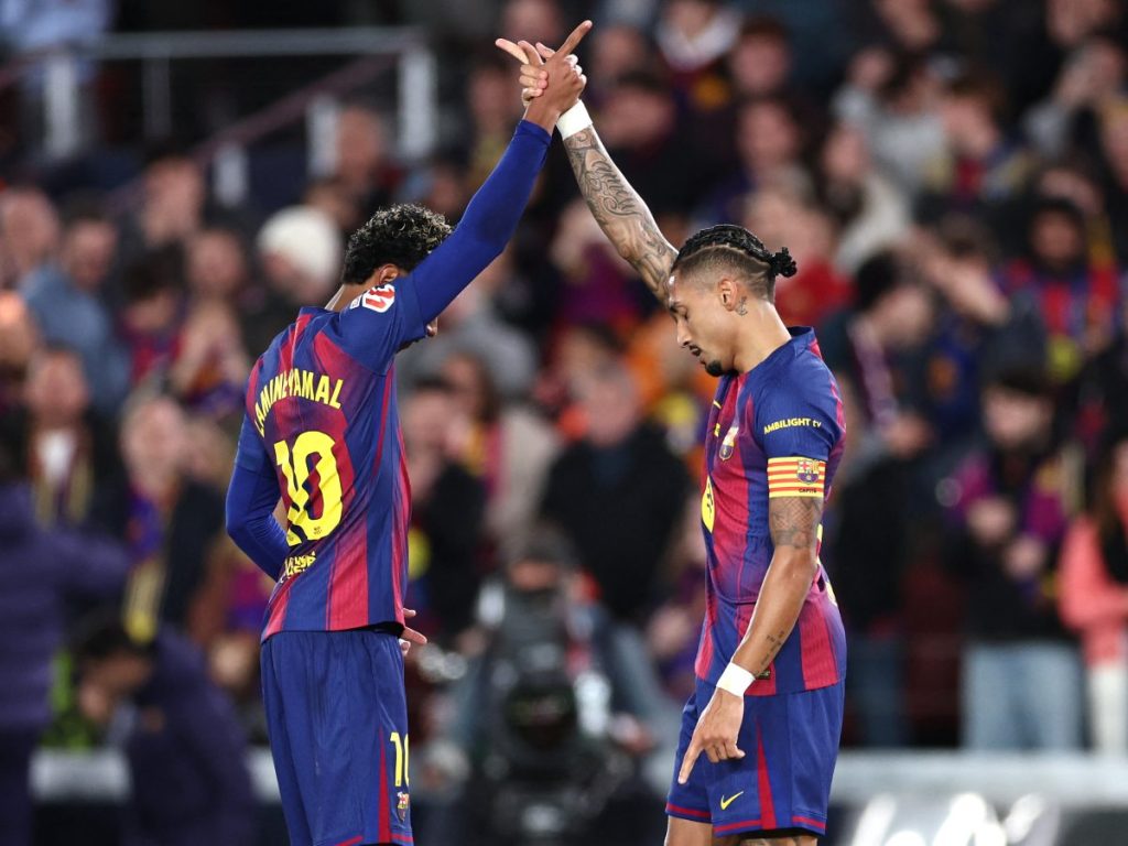 El delantero brasileño #11 del Barcelona, Raphinha, celebra con el delantero español #10 del Barcelona, Lamine Yamal, marcar el primer gol de su equipo durante el partido de fútbol de la liga española entre el FC Barcelona y el CA Osasuna en el Estadio Camp Nou en Barcelona el 13 de diciembre de 2025. (Foto AFP)