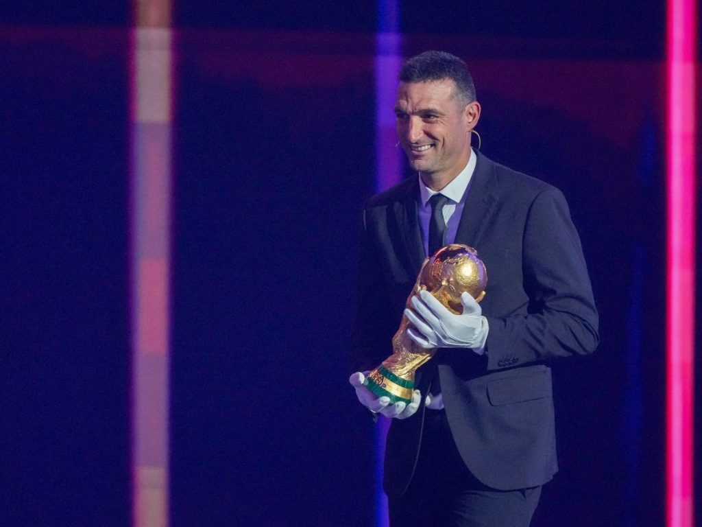 Lionel Scaloni, DT de Argentina, con la copa del mundo en el sorteo del Mundial. Foto AFP 