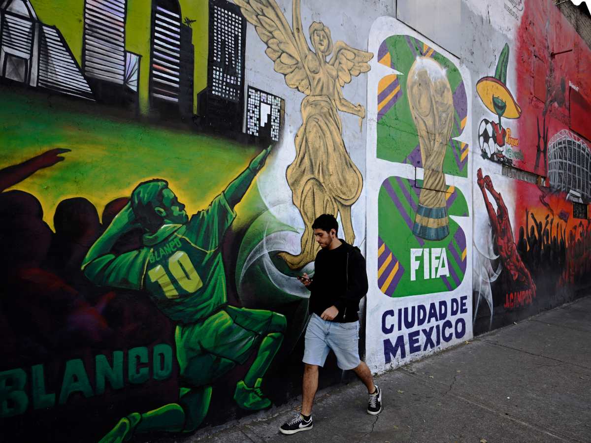 Un hombre pasa junto a un mural relacionado con la Copa Mundial de la FIFA 2026 en la Ciudad de México el 5 de diciembre de 2025.