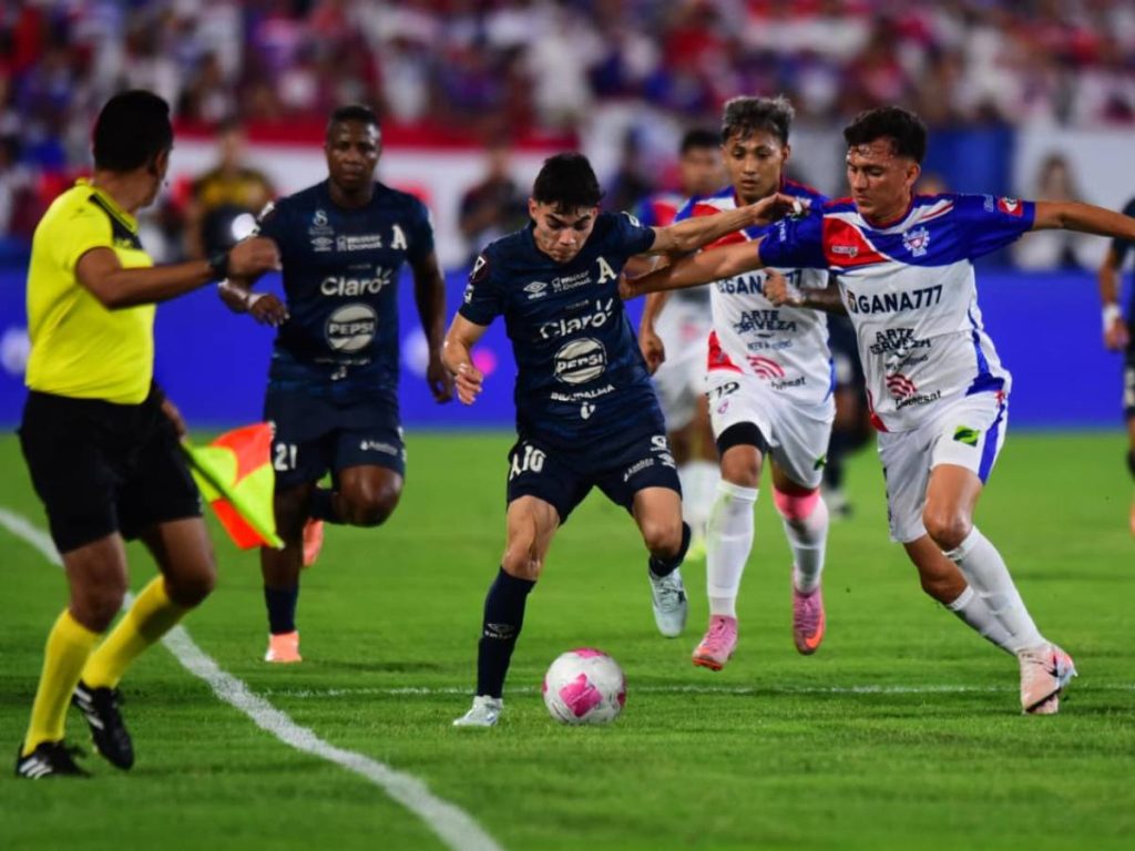 Alianza intenta progresar por la banda ante la presión de varios jugadores de Firpo durante la final en el estadio Mágico González.