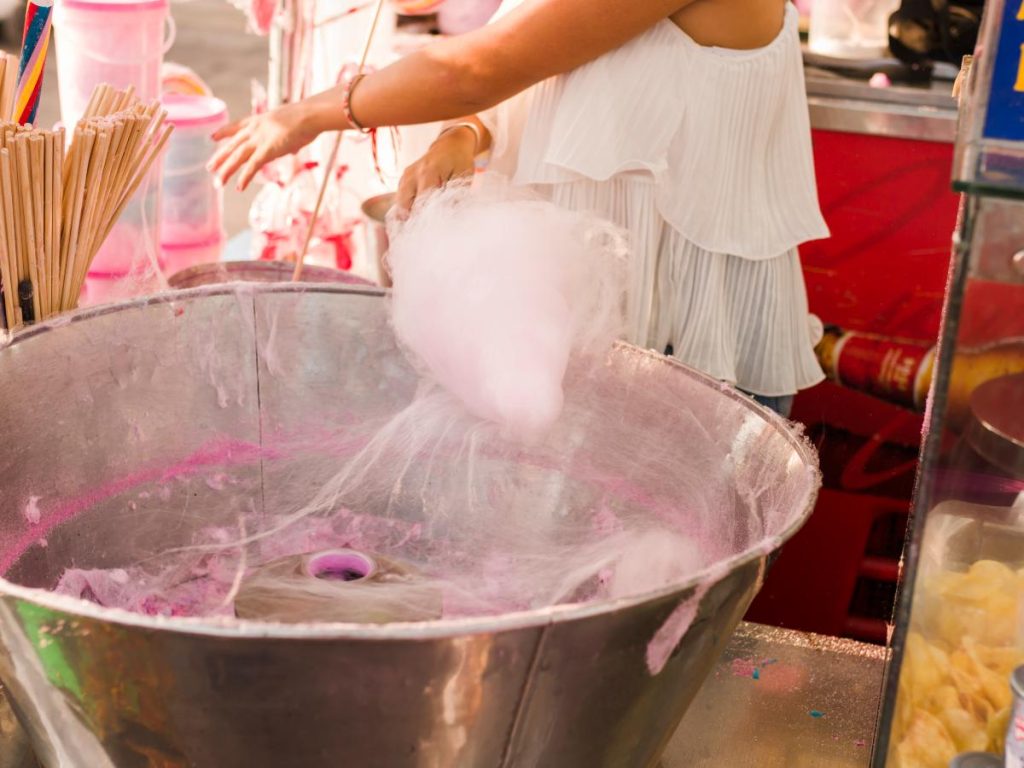 Elaborado con azúcar derretida y colorante vegetal, el algodón de azúcar toma forma con giros suaves hasta convertirse en una nube comestible.