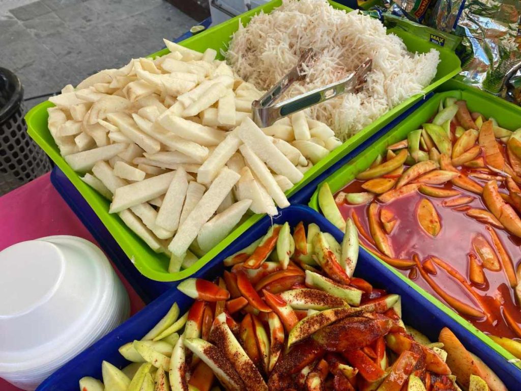 Mango, jícama, pepino y guindas se preparan al momento con limón, chile, alguashte, tajín y chamoy, una combinación que despierta los sentidos.