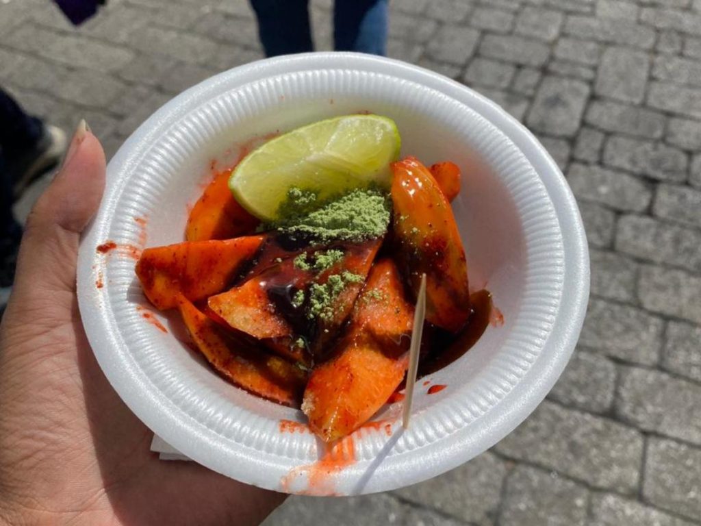 Las frutas frescas se exhiben en recipientes limpios y ordenados, cumpliendo estándares de salubridad para el consumo del público.