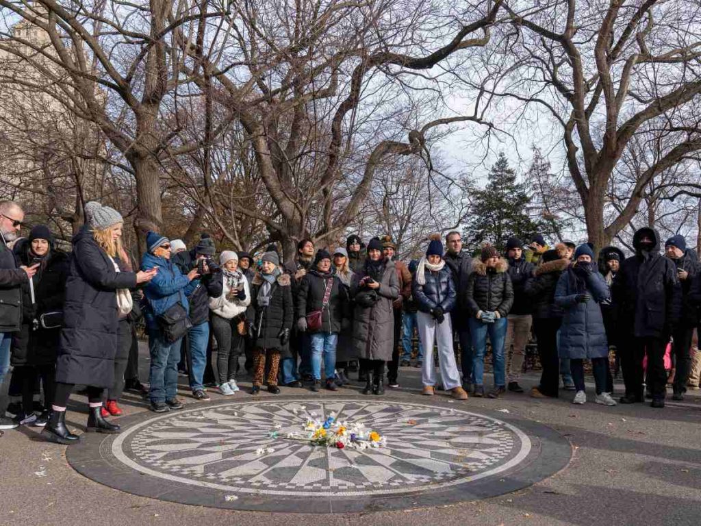 Personas participan en la conmemoración de los 45 años de muerte de John Lenon alrededor de un mosaico este lunes, en Nueva York (EE.UU.).
