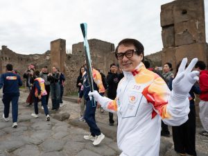 Pompeya, Italia. El actor hongkonés Jackie Chan sostiene la antorcha olímpica durante el relevo rumbo a Milán-Cortina 2026 en la zona arqueológica de Pompeya.