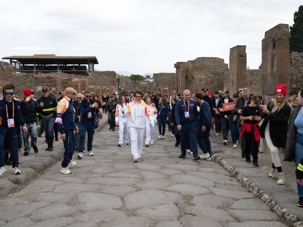 Jackie Chan porta la antorcha olímpica durante el relevo de Milán-Cortina 2026 al pasar por la zona arqueológica de Pompeya, en Italia.