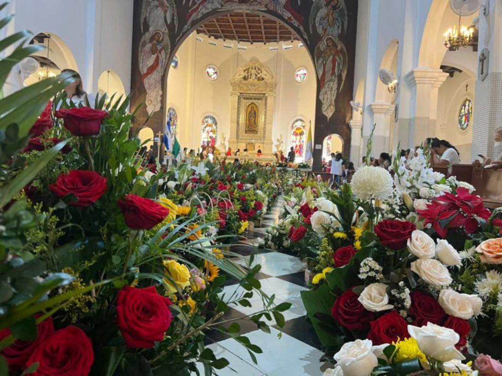 Ramos de flores cubren el altar como muestra de agradecimiento por los milagros atribuidos a la Guadalupana.