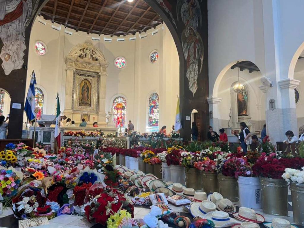 Las manos de Blanca Cubillas colocan las rosas por colores frente al altar de la Virgen de Guadalupe.