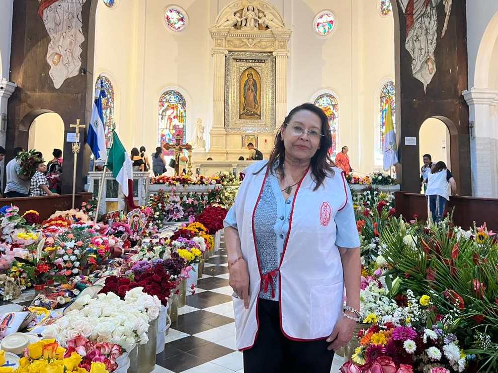 Blanca Lidia Cubillas recibe y organiza las flores que los feligreses llevan como ofrenda a la Virgen de Guadalupe en la Basílica de Antiguo Cuscatlán.