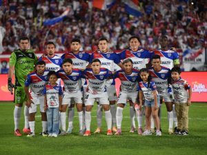 L.A. Firpo presenta su alineación inicial junto a niños acompañantes antes de disputar la final del Apertura 2025, en busca de su corona número 11.