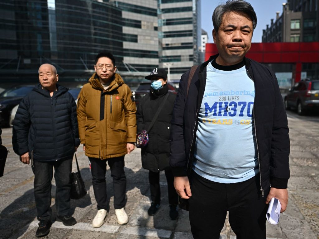 Jiang Hui (der.), familiar de un pasajero del vuelo MH370 de Malaysia Airlines desaparecido, junto a otros familiares desaparecidos, habla con los medios tras una reunión en Pekín el 8 de marzo de 2025, en el 11.º aniversario de la desaparición del vuelo. (Foto AFP)