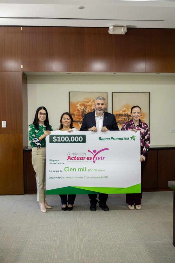 Representantes de Banco Promerica y FUNDACTUAR posan con el cheque simbólico durante el acto de entrega del donativo.