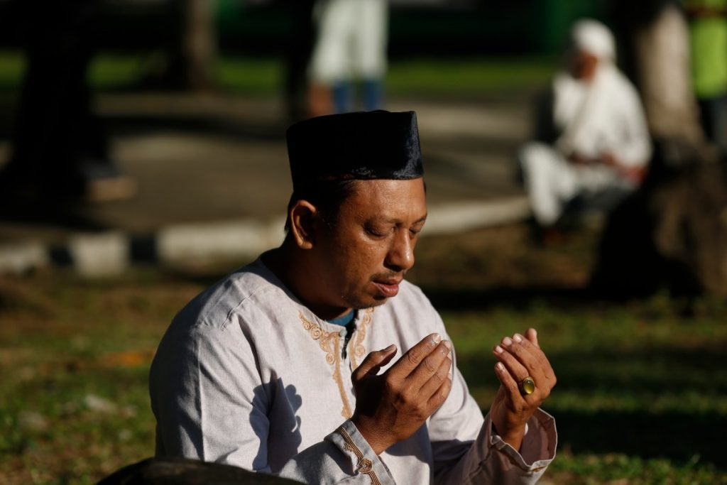 Los acehneses rezan y leen el Corán en la fosa común de Ulee Lhueu para las víctimas del tsunami, durante la ceremonia de conmemoración del tsunami de 2004 en Banda Aceh, Indonesia, el 26 de diciembre de 2025. 