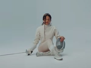 Rosalía aparece con traje de esgrima en una de las escenas del videoclip de La Perla, una imagen que refuerza la estética simbólica y contenida de su álbum Lux.